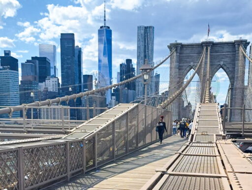Walking on Brooklyn Bridge towards Manhattan with view of One World Trade Center