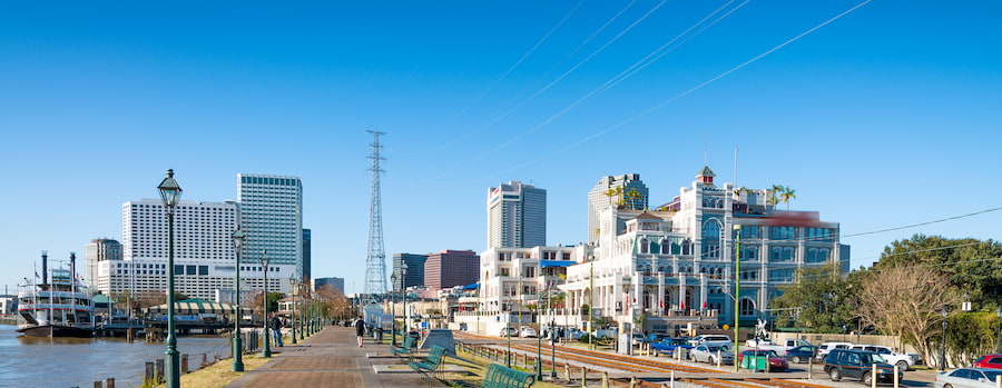 New Orleans riverfront boardwalk with a steamboat and the historic Jax Brewery