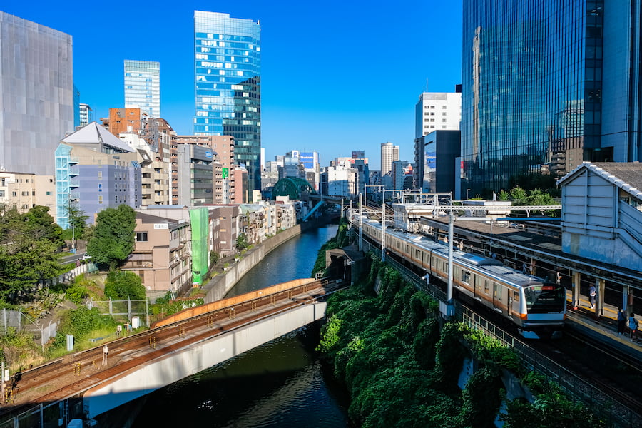 Urban view from Hijiribashi Bridge showing trains at Ochanomizu Station and the Kanda River in Tokyo, Japan
